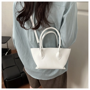 Close-up of a white lychee grain leather bucket bag with top handles and thin strap