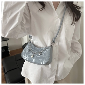 Detail view of light blue shoulder bag with metal chain and decorative pearl charms