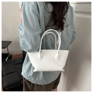 Detailed view of white lychee leather texture on a stylish bucket bag for women