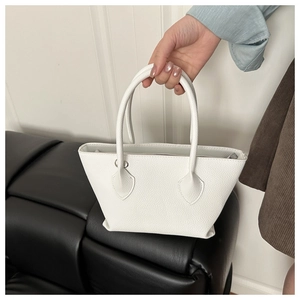 Close-up of white lychee pattern leather bucket bag showing grain texture and round handle