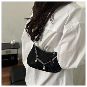 Detail of black jacquard shoulder bag with decorative silver chain and star heart charms