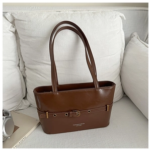 Détail du sac cabas marron avec boucle de ceinture décorative et lettrage élégant