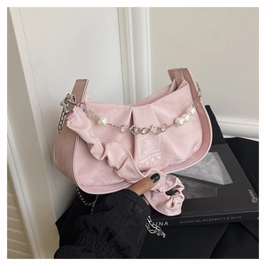 Close-up of pink pleated suede bag with white pearls and metal petal chain strap