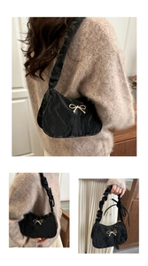 Détails du sac nuage noir plissé avec fermoir papillon doré et bandoulière froncée
