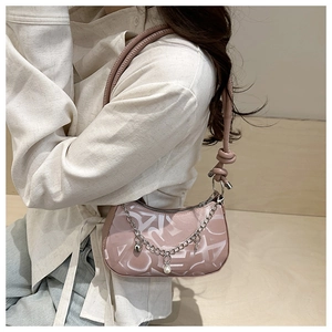 Sac sous le bras rose avec chaîne argentée, perle factice et pendentif cœur sur le sac à main