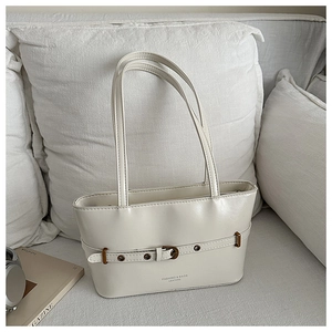 Gros plan du sac cabas crème en cuir avec boucle décorative et coutures de précision