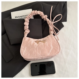 Détail du sac à bandoulière rose plissé avec boucle nœud doré et poignée froncée