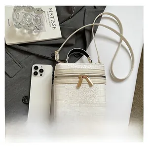 Mini white crocodile texture box bag size comparison with a smartphone and art book