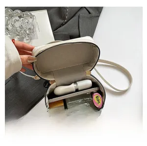 Internal view of the white round crossbody bag showing storage for phone and cosmetics