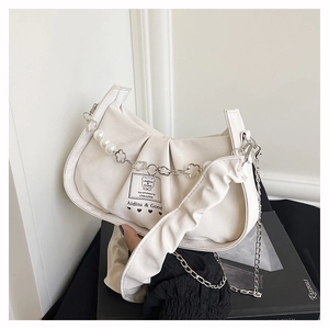 Detail of ruched cloud handbag featuring pearl bead chain and branded woven label