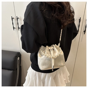 Detail of drawstring bucket bag with pearl handle and Chinese style floral pattern