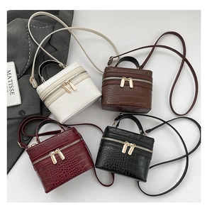 Detailed top view of four faux crocodile leather box bags in white, brown, red and black
