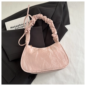 Détail de la texture plissée rose brillant et de la bandoulière d'un sac à main chic