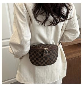 Close-up of vintage crescent waist bag with classic M letter print and gold zippers