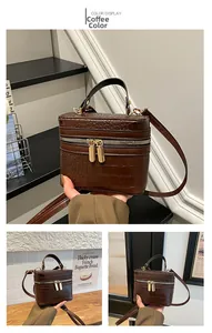 Detail view of brown crocodile embossed mini box bag with gold-tone hardware and top handle
