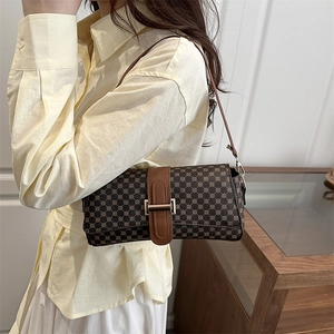 Retro brown shoulder bag with geometric print and gold metal clasp worn by model