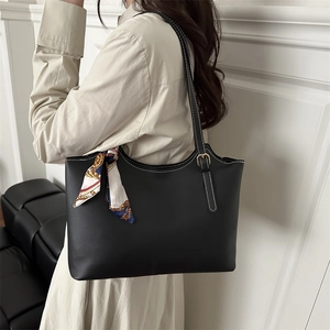 Classic black tote bag with white contrast stitching and a patterned silk scarf accessory