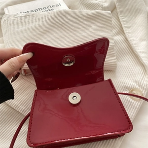 Red patent leather crossbody bag with metallic magnetic buckle and slim shoulder strap