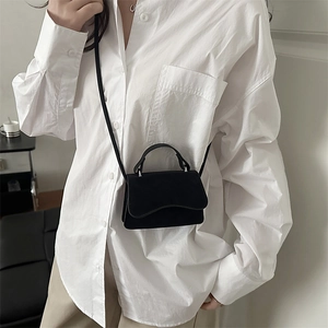 Retro black matte crossbody small square bag with top handle worn by a model