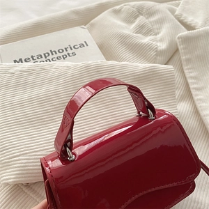 Vintage dark red patent leather handbag with silver hardware and curved flap design