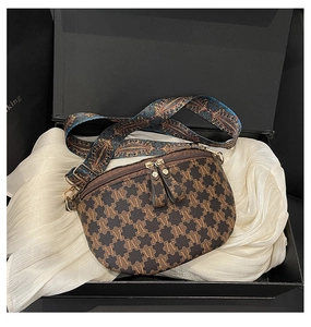 Detail view of monogram fanny pack with golden zippers in a premium gift box