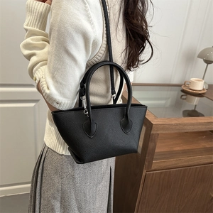 Minimalist black lychee texture bucket bag with top handle and adjustable strap for women