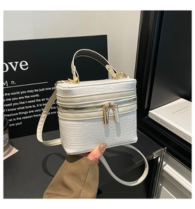 Detailed view of white crocodile embossed mini box bag with gold-tone hardware and handle