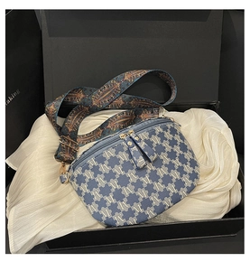 Detail of blue crescent bag with jacquard pattern and vintage woven shoulder strap