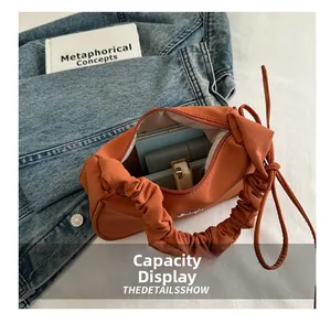 Interior view showing the large capacity of the orange pleated handle shoulder bag
