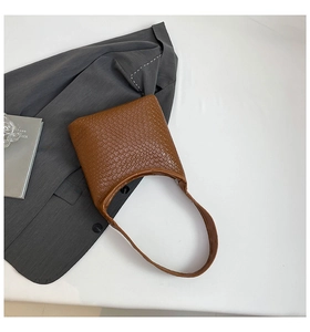 Detail of brown faux crocodile leather texture on hobo bag with a structured half-moon design
