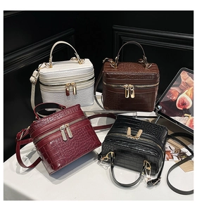 Detail of crocodile pattern box handbags in white, brown, burgundy and black colors