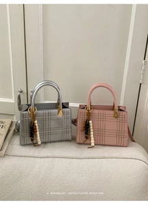 Detail of silver and pink quilted handbags with wooden bead tassels on a soft surface