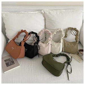 Close-up of crescent-shaped underarm bags in six colors with bow and ruched handles