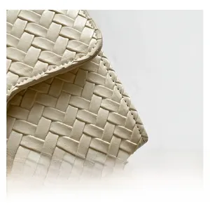 Gros plan sur la texture tressée crème et les surpiqûres de précision du sac à main