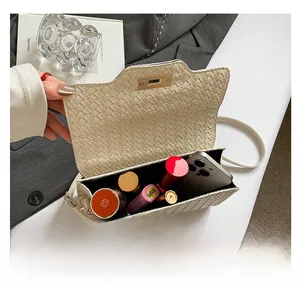 Capacité intérieure du sac bandoulière en cuir tressé crème avec articles de maquillage