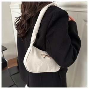 Gros plan d'un sac plissé beige avec un fermoir papillon doré élégant en métal