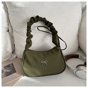 Detail of army green crescent shoulder bag with ruched strap and silver bow charm