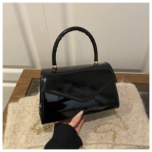 Black patent leather envelope handbag with a curved handle and a gold chain strap detail