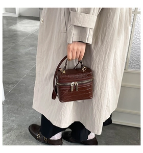 Deep brown crocodile textured mini box bag shown in a classic lifestyle setting