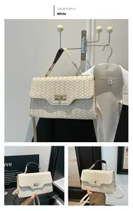Détail d'un sac à main blanc tressé avec fermoir doré rotatif et bandoulière réglable