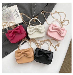 Detailed display of five colorful mini handbags with large bows and pearl handles