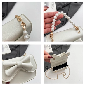 Detail view of cream bow handbag showing pearl handle, gold hardware, and interior
