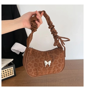 Detail of leopard print handbag with silver butterfly buckle and ruched handle design