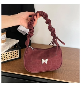 Close-up of burgundy leopard print hobo bag with scrunchie handle and silver butterfly