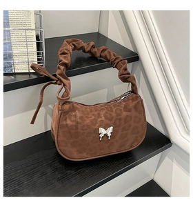 Detail of leopard print handbag with silver butterfly buckle and pleated shoulder strap