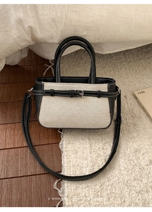 Vue détaillée du tissu tissé et du contraste en cuir noir sur ce sac seau rétro