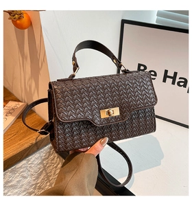 Détail du sac à main tressé marron foncé avec fermoir doré et poignée supérieure