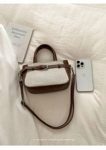 Detail of two-tone brown leather and canvas crossbody bag with adjustable strap