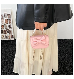 Vista dettagliata della mini borsa rosa con manico di perle e catena dorata