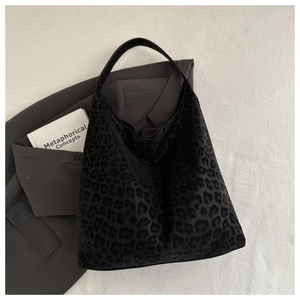 Detail of a black leopard print hobo tote bag featuring a soft flocked texture and large capacity